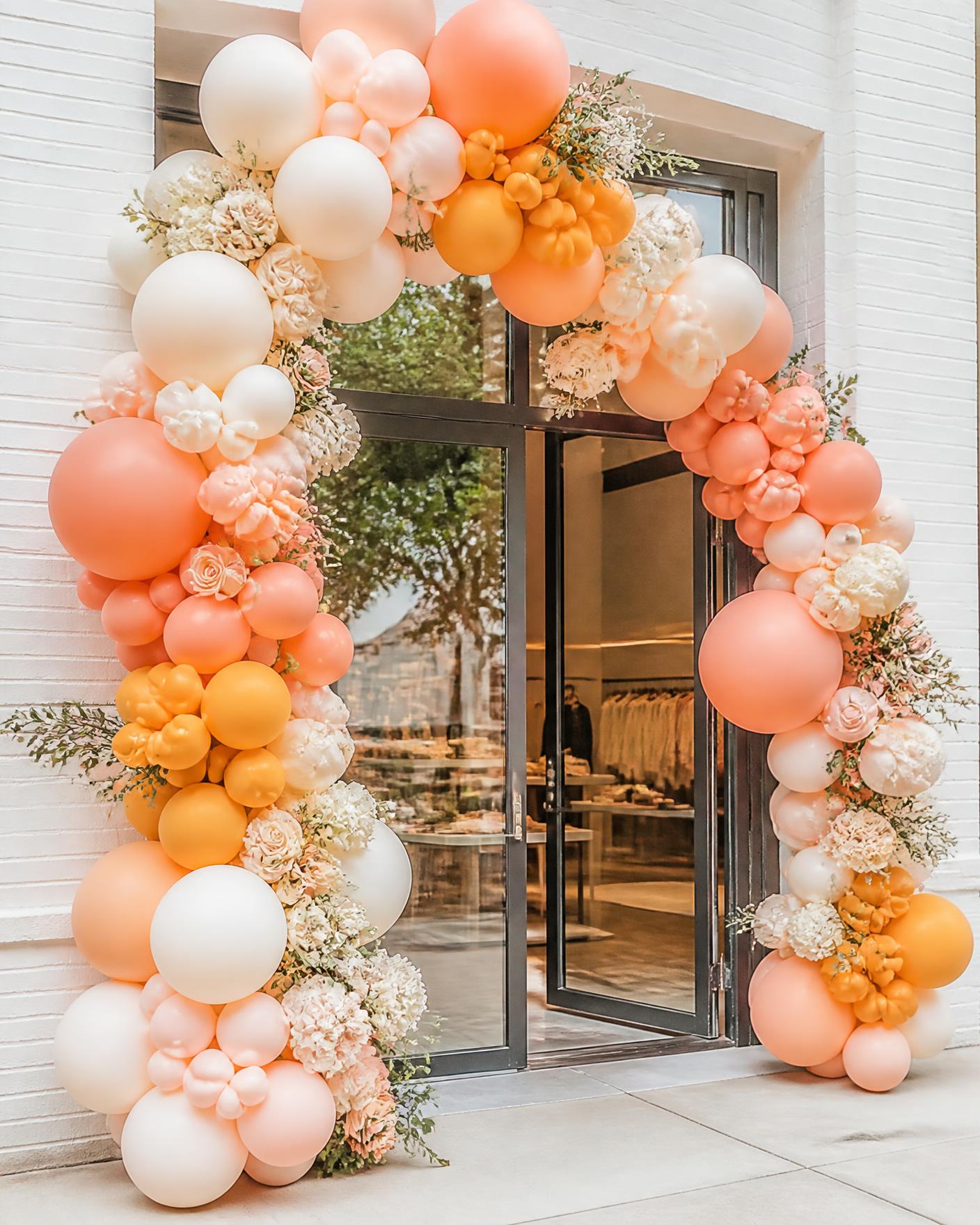 Balloon garland arch framing a boutique storefront entrance